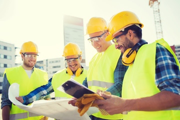 group of builders with tablet pc and blueprint