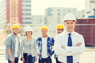 group of smiling builders in hardhats outdoors