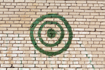Green painted target on brick wall.