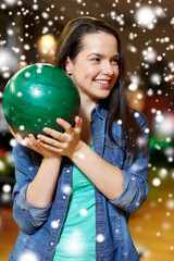 Naklejka premium happy young woman holding ball in bowling club