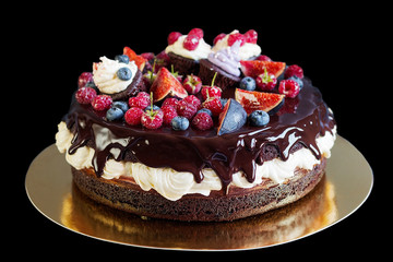 Layered chocolate cake with fruit. Isolated on black