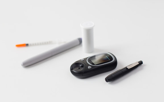 close up of glucometer, insulin pen and syringe