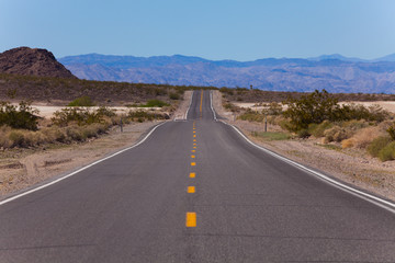 Fototapeta na wymiar Straight road with lines in desert, California
