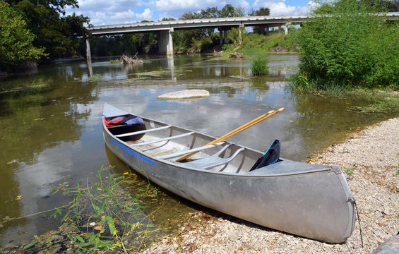 Canoe/ Metal canoe parked on a bank with road bridge in the background