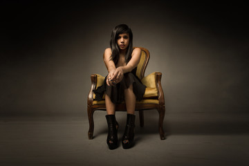 Fototapeta premium girl sitting on a yellow sofa