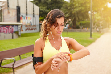 Young jogger looking at smart watch while standing