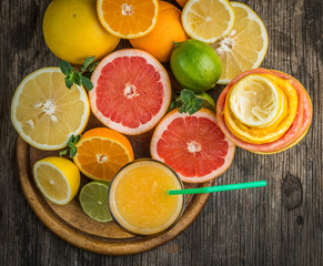Fototapeta na wymiar Citrus juice and fruits on vintage wooden background