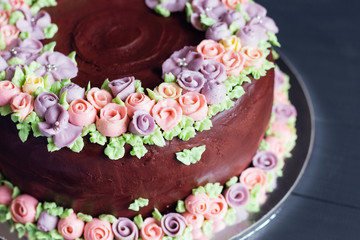 Obraz na płótnie Canvas Homemade chocolate cake with colorful cream flowers