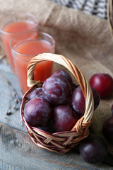 Delicious plum juice with fruits on table close up
