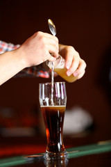 Bartender is pouring beer into glass