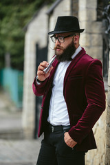 rich man with a beard smokes electronic cigarette