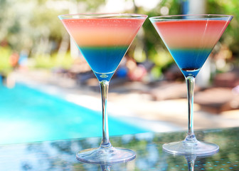 Cocktails on swimming pool background