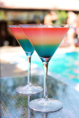 Cocktails on swimming pool background