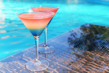 Cocktails on swimming pool background