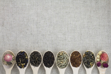 Assortment of different types of tea in a wooden spoon