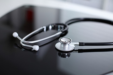 Stethoscope on black, reflective background