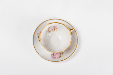 Obraz na płótnie Canvas Antique porcelain tea cup with floral painting on white backgrou