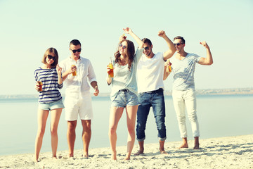 Obraz premium Young people with beer on the riverside