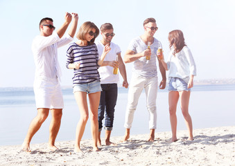Obraz premium Young people with beer on the riverside