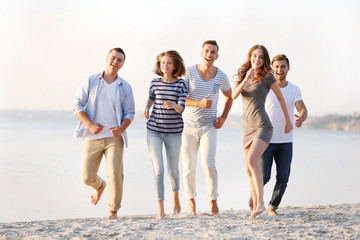 Young people with beer on the riverside