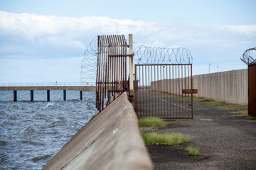 Gate behind Cockenzie Power station next to the sea, Scotland