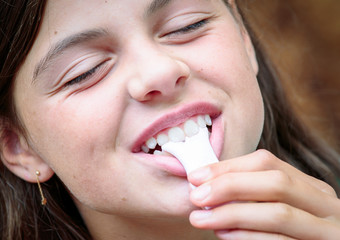 closeup of pretty young girl tasting a delicious sweet