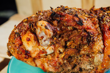 great fresh baked turkey leg and sliced piece sprinkled with spices lying on a blue plate to black wooden background