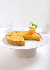 Tangerine creme brulee tart on a white background