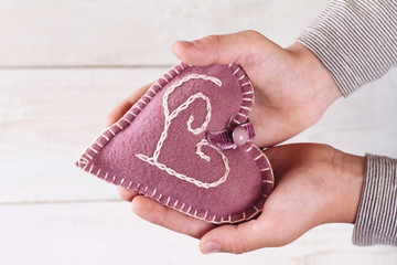 Close up on up on child's  hands holding a heart. Love, handmade, valentine concept