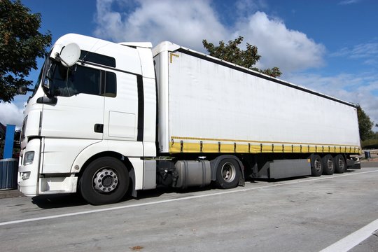 Sattelschlepper mit Schiebeplanenauflieger auf einem Autobahnrastplatz