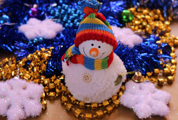 The white snowman on a background of festive decorations and ornaments.Сhristmas toys