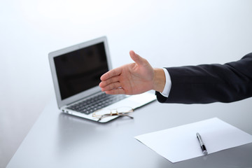 Close-up of  businessman at the table giving a hand