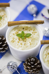 Rice Pudding with Cinnamon, New Year Ornaments in Blue Color, Pine cones and Candle