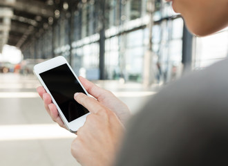 Woman using mobile phone at the airport terminal