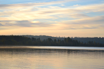Autumn forest on the lake at sunrise.