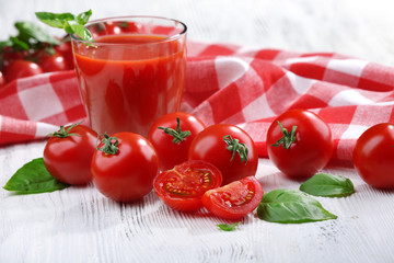 Glass of tomato juice on wooden table, closeup