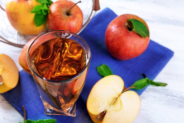 Glass of apple juice with fruits and fresh mint on table close up
