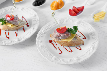 Tasty canapes on wooden table, close up