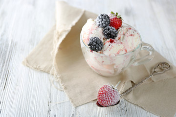 Delicious ice cream with fresh frozen berries, on color wooden background