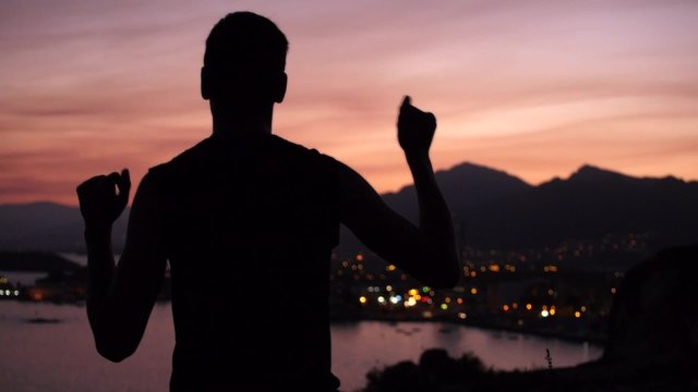 hombre bailando haciendo el tonto paisaje costa puesta de sol
