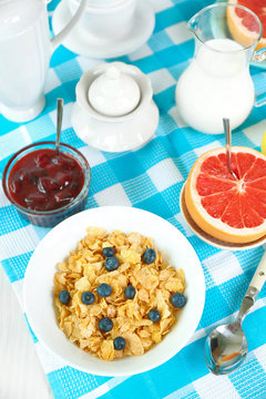 Tasty cornflakes with fruits and berries on table close up