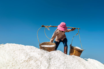 Farmer is carrying salt baskets, Vietnam.