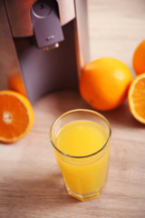 Juicer and orange juice on kitchen table