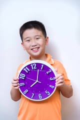 Asian boy showing and holding purple or violet clock in studio s