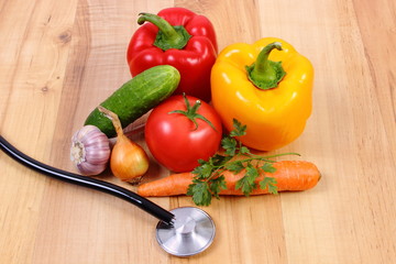 Fresh vegetables and stethoscope on wooden surface, healthy lifestyle and nutrition