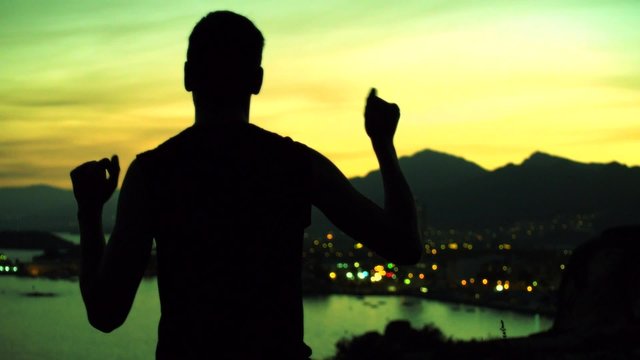 hombre bailando haciendo el tonto paisaje costa puesta de sol