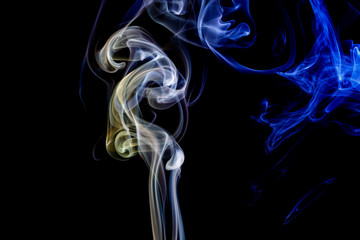Abstract blue and yellow smoke from the aromatic sticks.