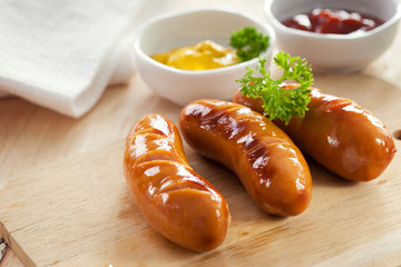 grilled sausage on wooden block