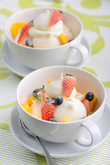 Two cups of Pavlova dessert with mango berry strawberry