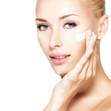 Beauty face of woman applying cosmetic cream on face